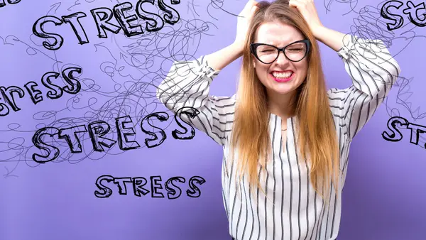 En kvinde tager sig til hovedet pga. stress