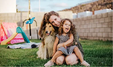 Kvinde sidder med sit barn og hun i haven