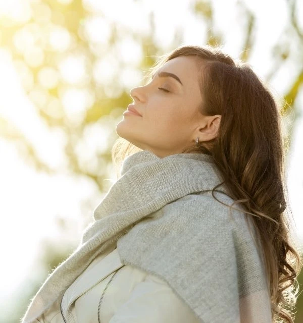 Kvinde står i naturen og har det godt og nyder livet